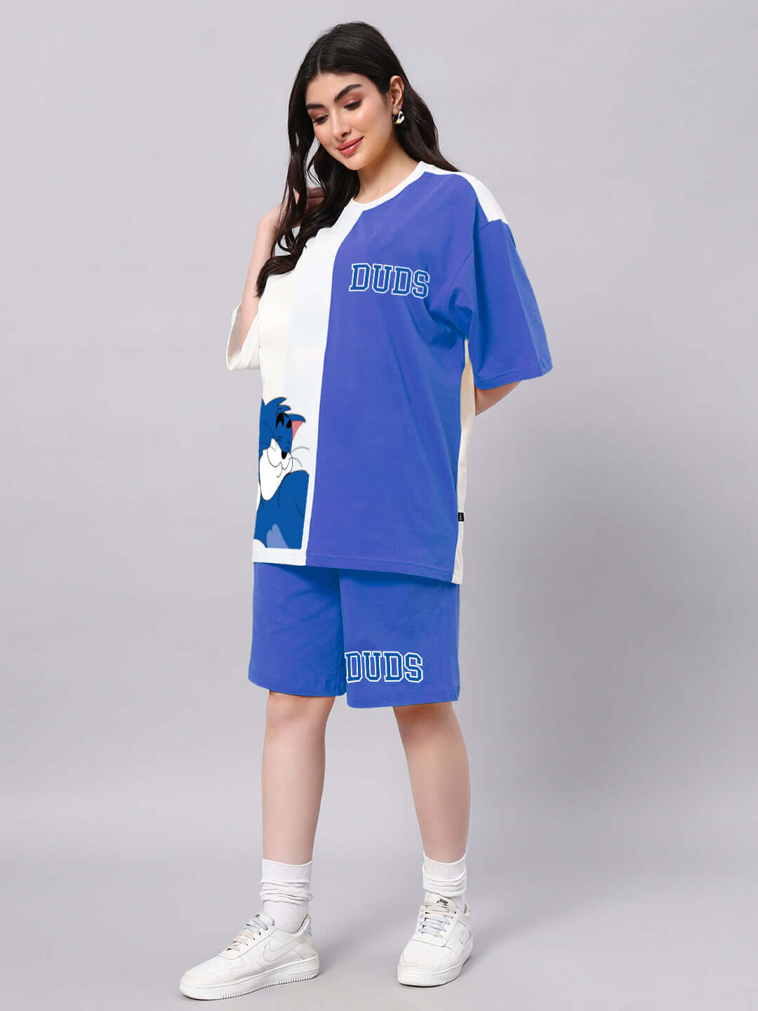 Model wearing WOMEN CAPER TOM CO-ORD SET BLUE OFF-WHITE with cartoon design, featuring short-sleeve top and shorts, suitable for summer.