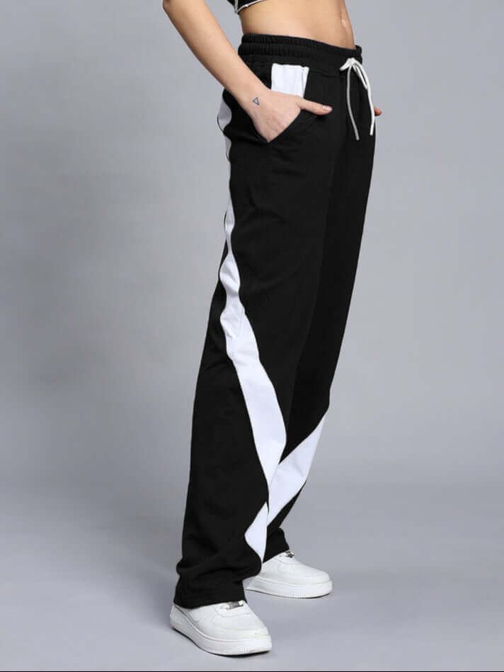 Woman wearing Celestine Relaxed Fit Jogger in Black-White with white sneakers, showcasing side view and comfortable fit.