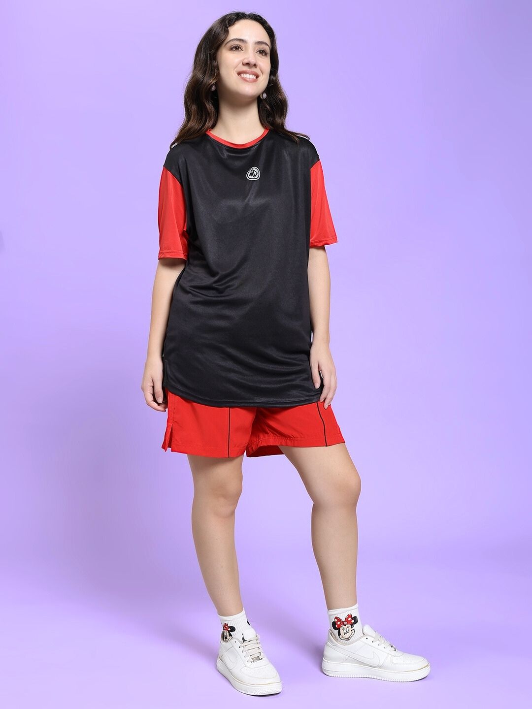 Woman wearing WOMEN CHAMPION ZONE REGULAR FIT CO-ORD SET BLACK RED, showcasing sporty streetwear in black and red design.