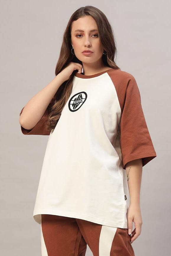 Model wearing women's chestnut raglan blocked oversized t-shirt in off white and brown with logo, made of 97% cotton French terry.