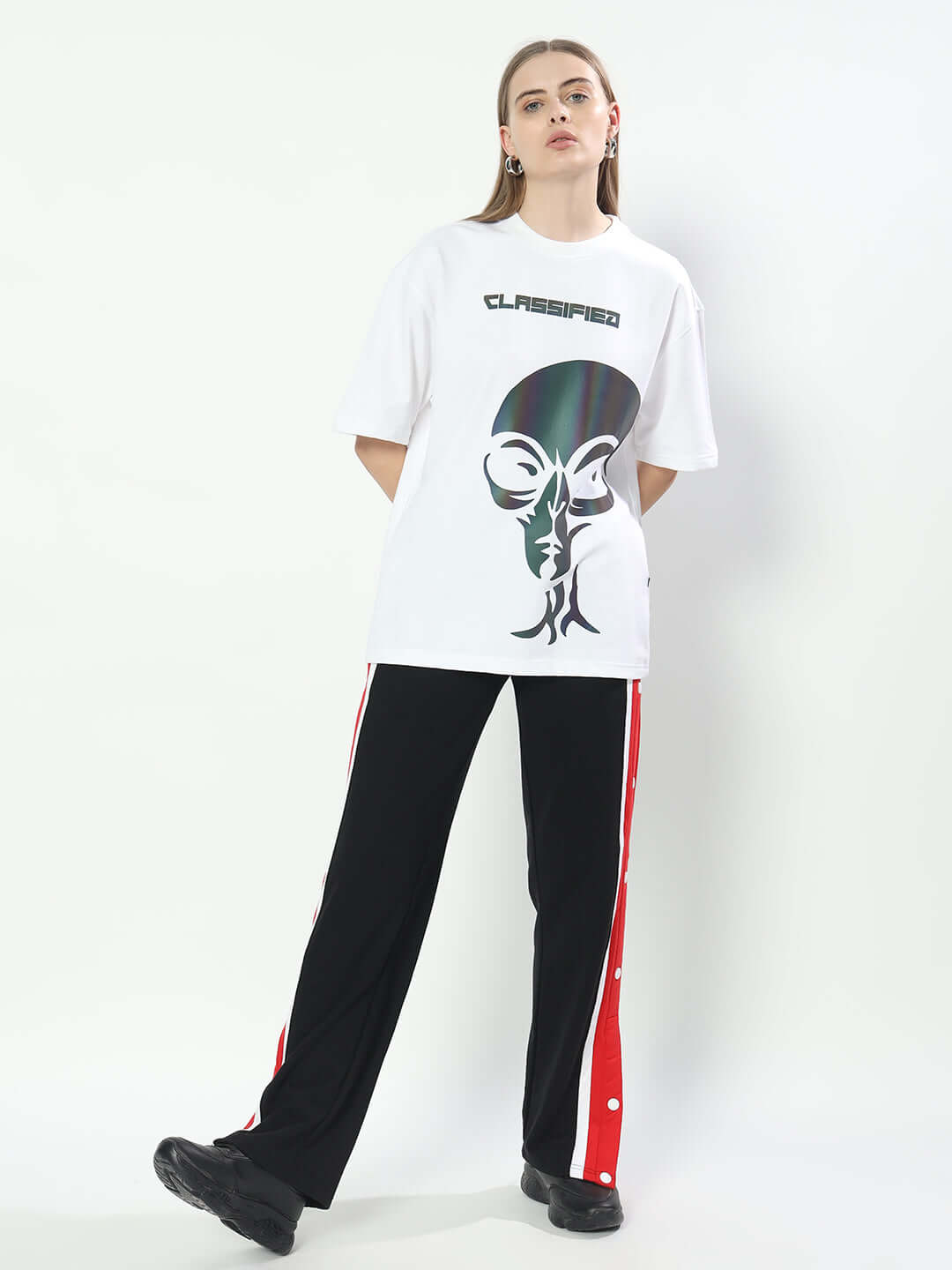 Model wearing a women's oversized white t-shirt with graphic design, emphasizing premium fabric and street style.
