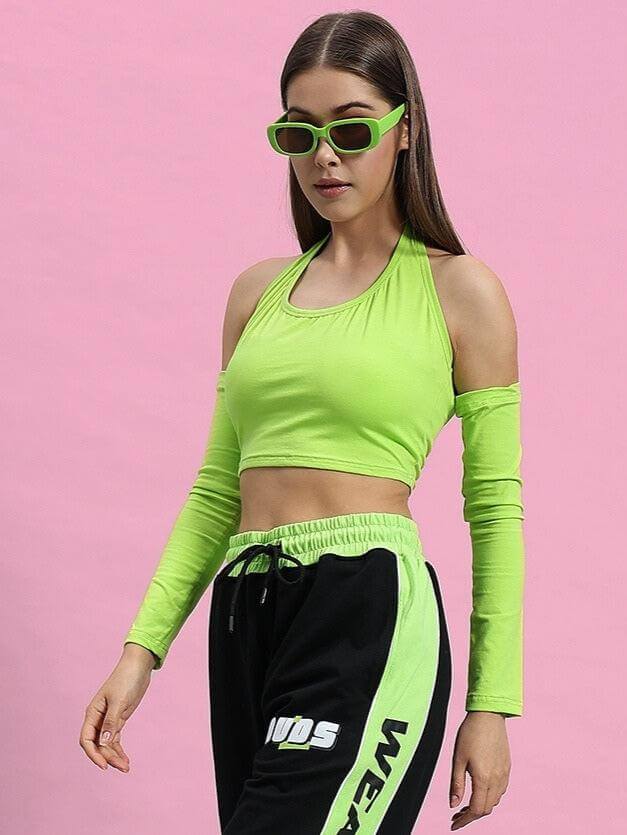 Woman wearing WOMEN CLUTCH CROP-TOP NEON GREEN in a stylish fashion pose against a pink background.