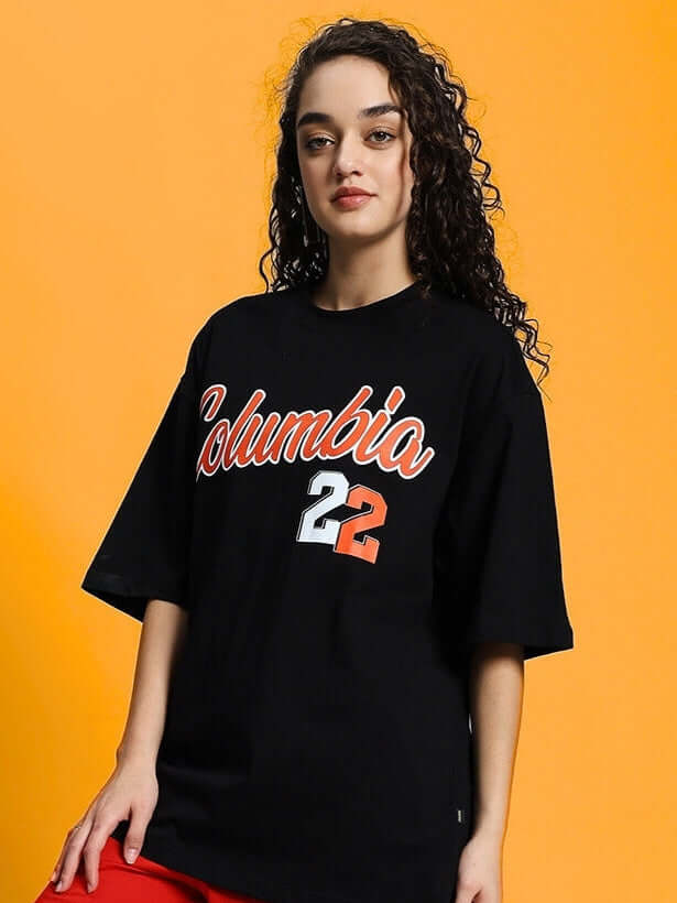 Woman wearing a black oversized Columbia 22 print T-shirt made of premium cotton fabric, perfect for casual style. Made in India.