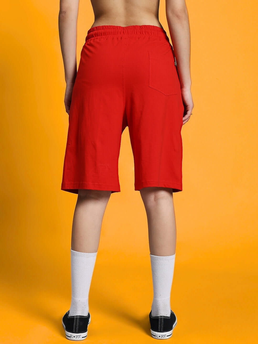 Back view of women's Columbia red regular fit shorts showcasing comfortable design and elastic waistband.