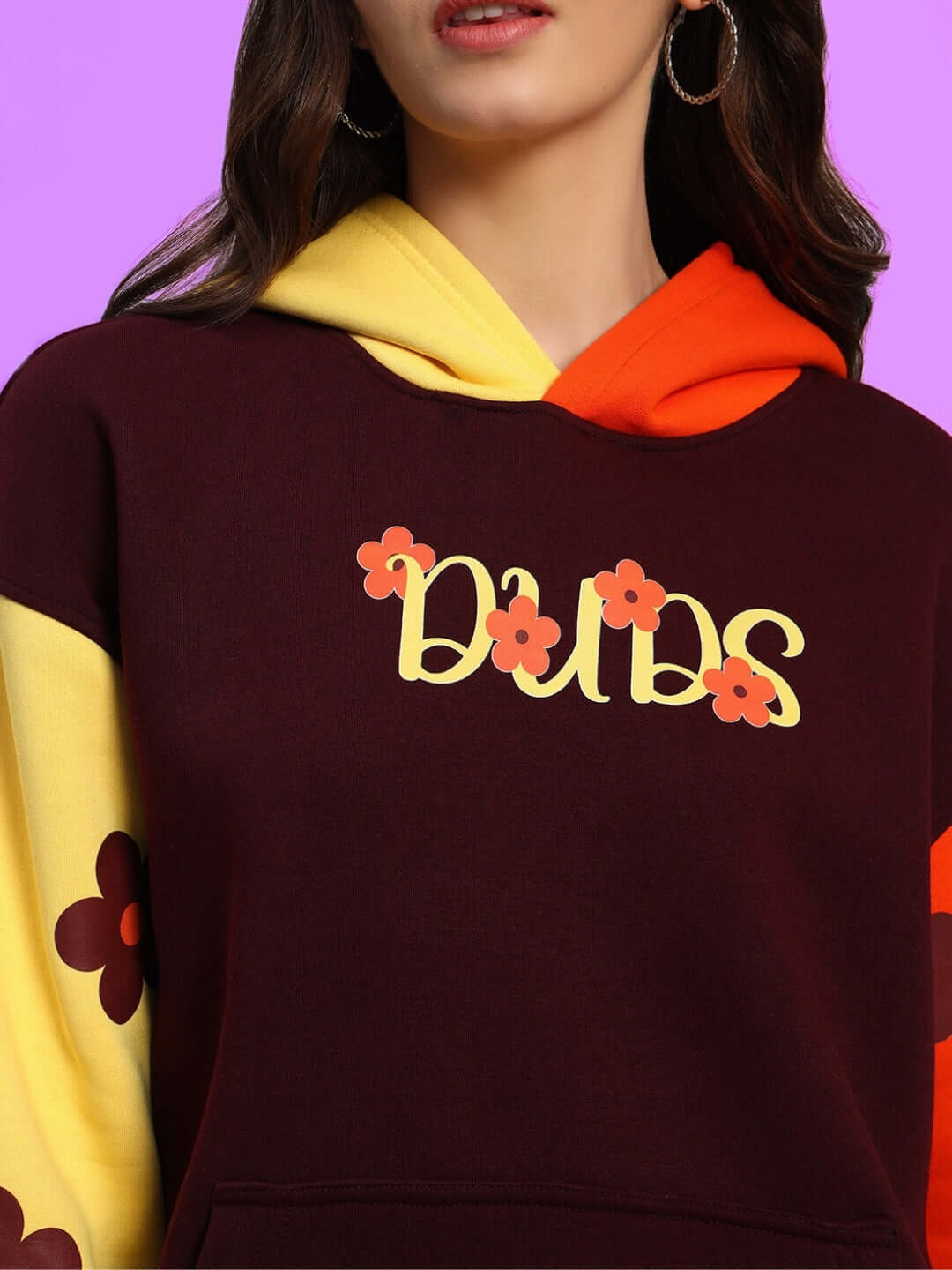 Women's oversized fleece hoodie with floral graphics and vibrant colors on a purple background.