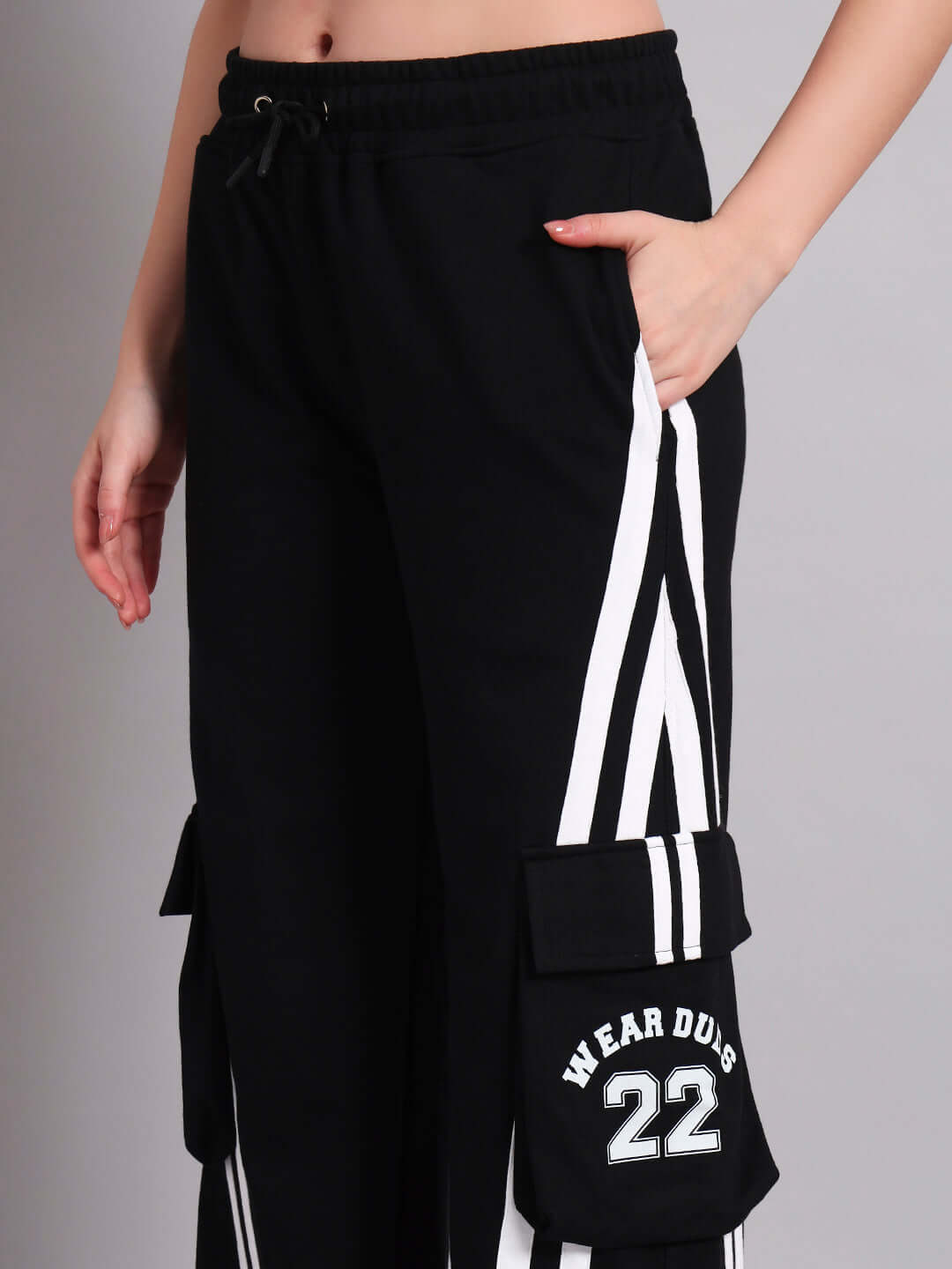 Woman wearing WOMENS CRUCIS MULTI POCKET RELAXED-FIT JOGGERS BLACK showing side pockets and stripe design.