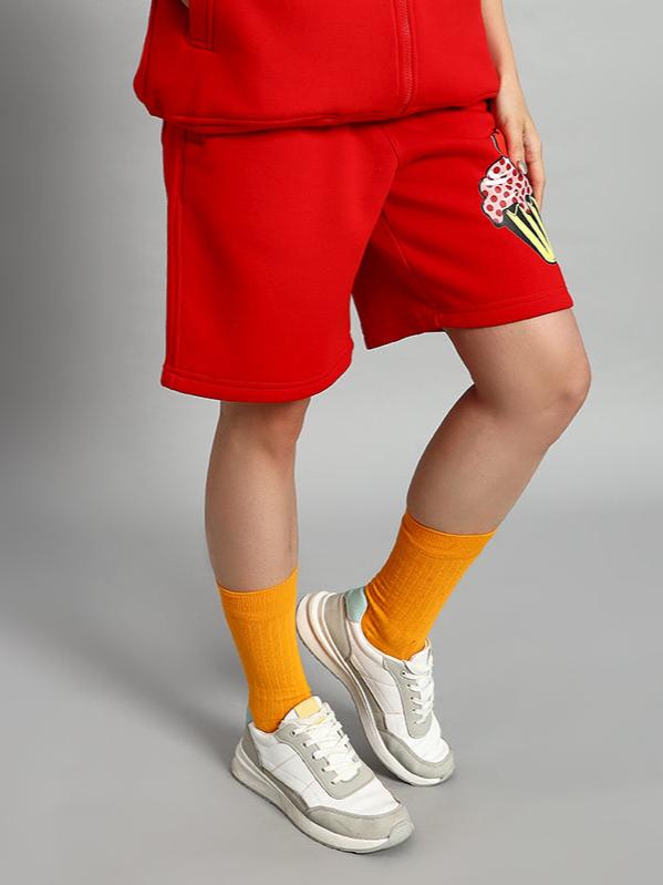 Woman wearing WOMEN CUPCAKE FLEECE SHORTS RED with sneakers and orange socks, featuring soft fleece and vibrant red color.