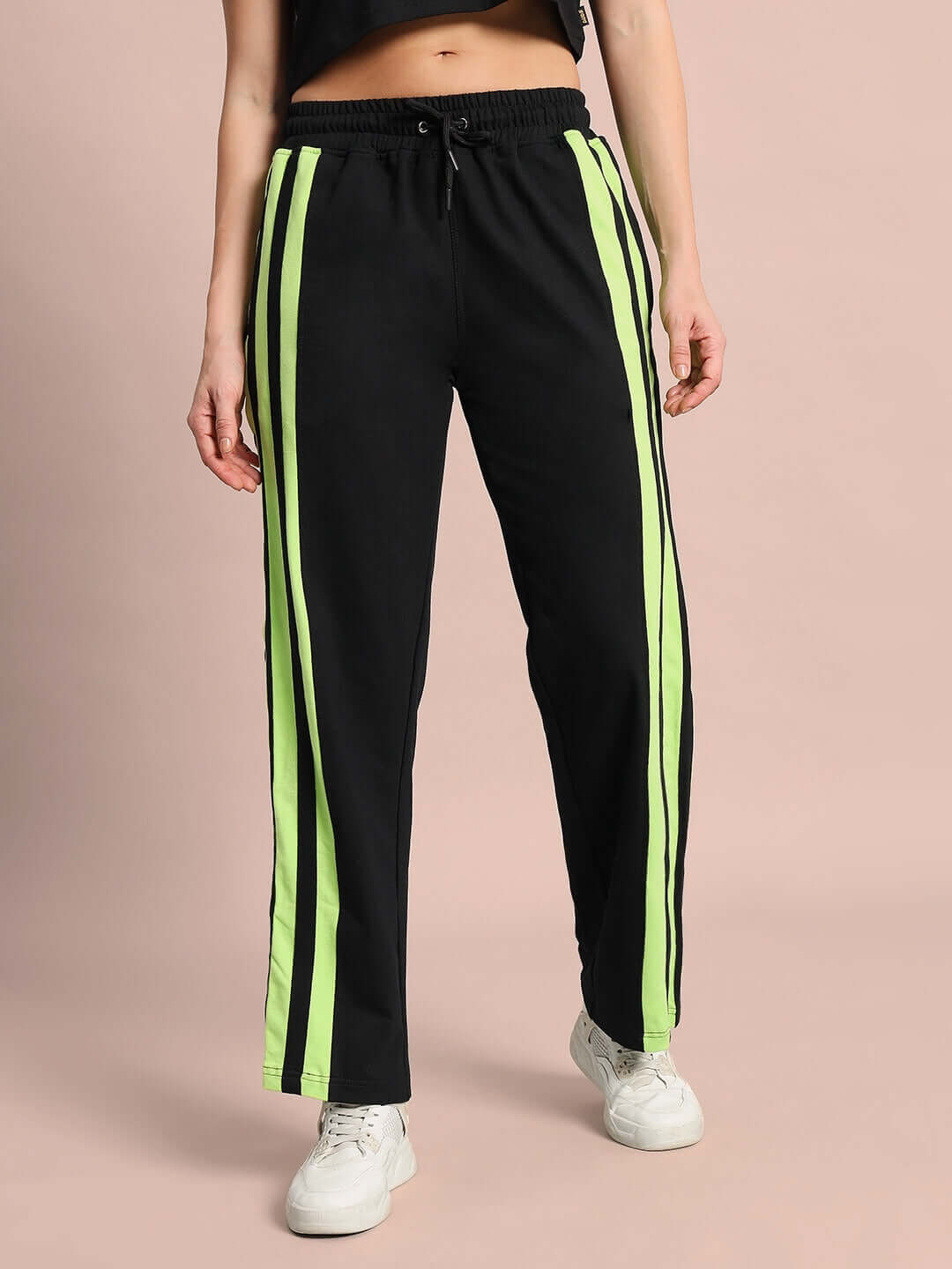 Woman wearing black joggers with neon green stripes, sporty fashion, customizable fit, women's dancer joggers by DUDS.