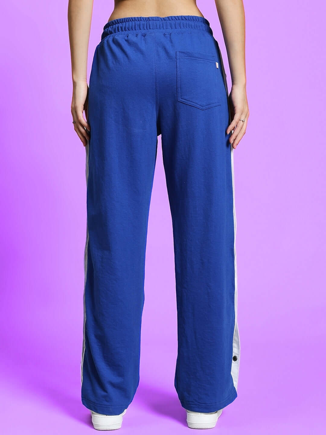 Back view of women's royal blue joggers with white stripe, featuring elastic waistband and back pocket, made to order by DUDS.