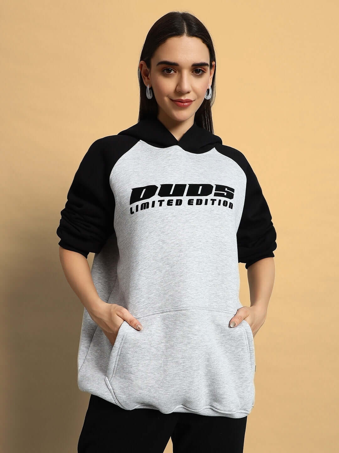 Woman wearing WOMEN DELUXE FLECCE OVERSIZE HOODIE BLACK MELANGE GREY with stylish design and roomy pockets.