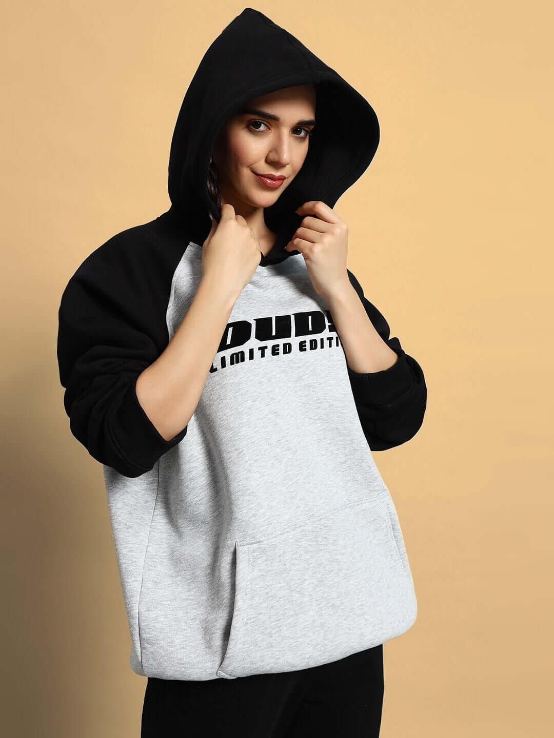 Woman wearing WOMEN DELUXE FLECCE OVERSIZE HOODIE BLACK MELANGE GREY, showcasing modern streetwear style.