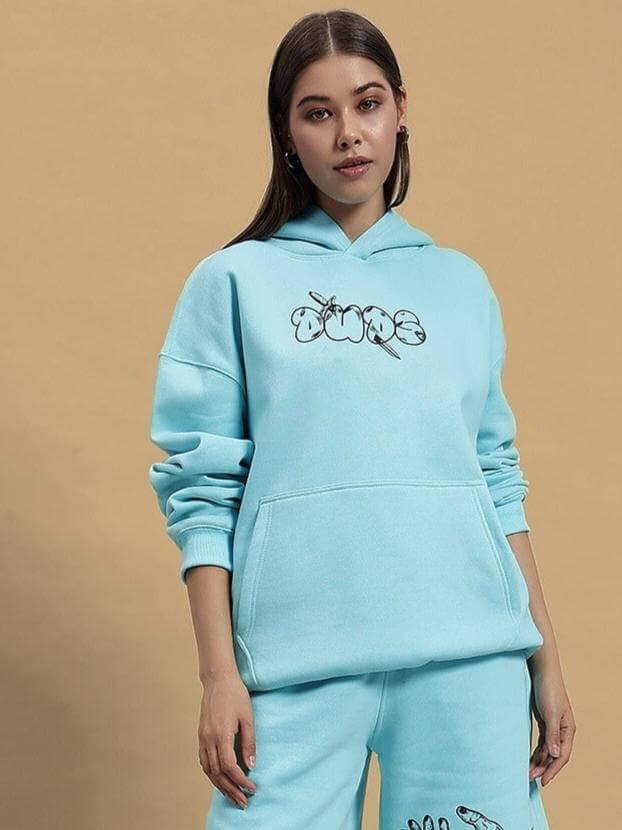 Woman wearing WOMEN DEMON FLEECE HOODIE SKY BLUE, showcasing casual style and comfort with front pocket and graphics.