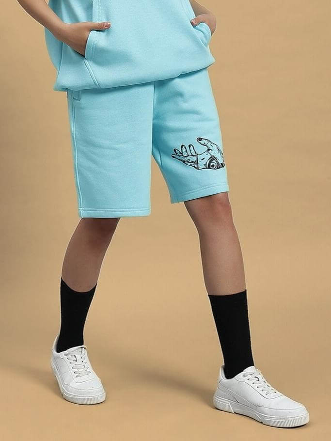 WOMEN DEMON FLEECE SHORTS SKY BLUE worn by model, showcasing comfortable fit and embroidery detail, perfect for stylish casual wear.