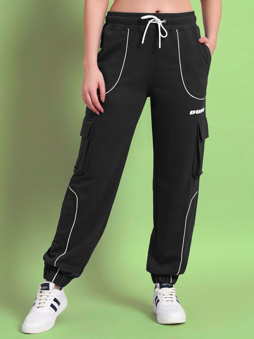 Model wearing black Women's Deveno Relaxed-Fit Joggers by DUDS, showcasing comfortable and stylish design with white sneakers.