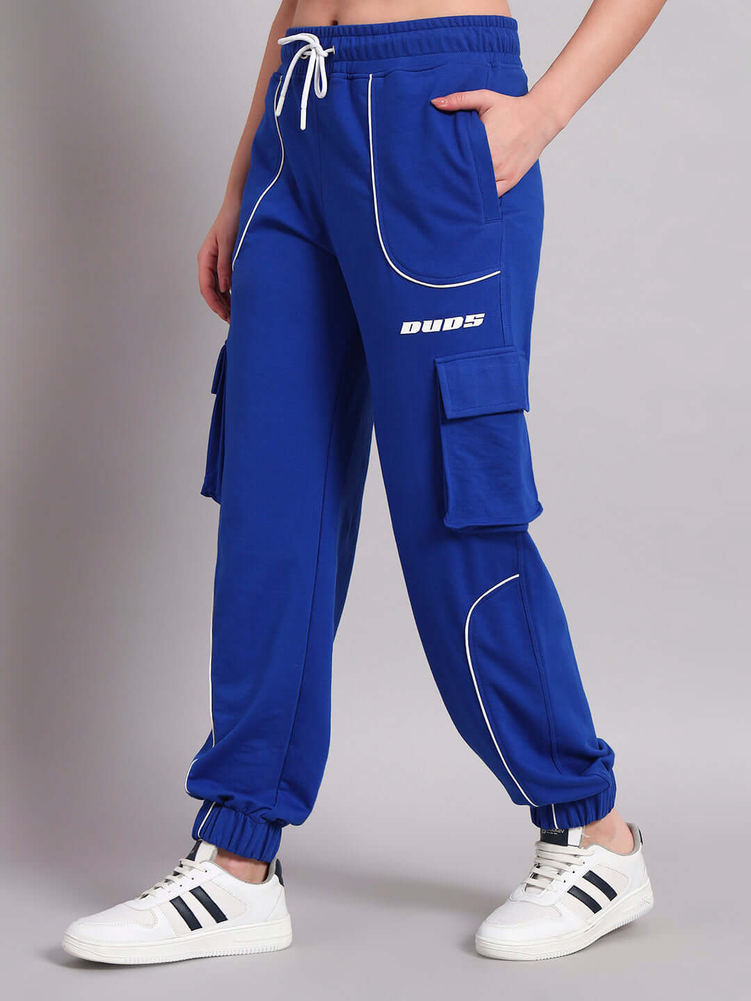 Women's blue relaxed-fit joggers by DUDS, showcasing side pockets and adjustable waistband for comfort, paired with white sneakers.