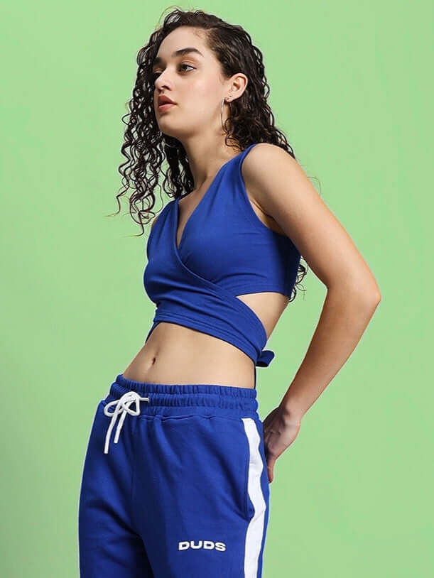 Model wearing a royal blue women's Dilly crop-top made from 100% cotton, styled for a sporty look against a green background.