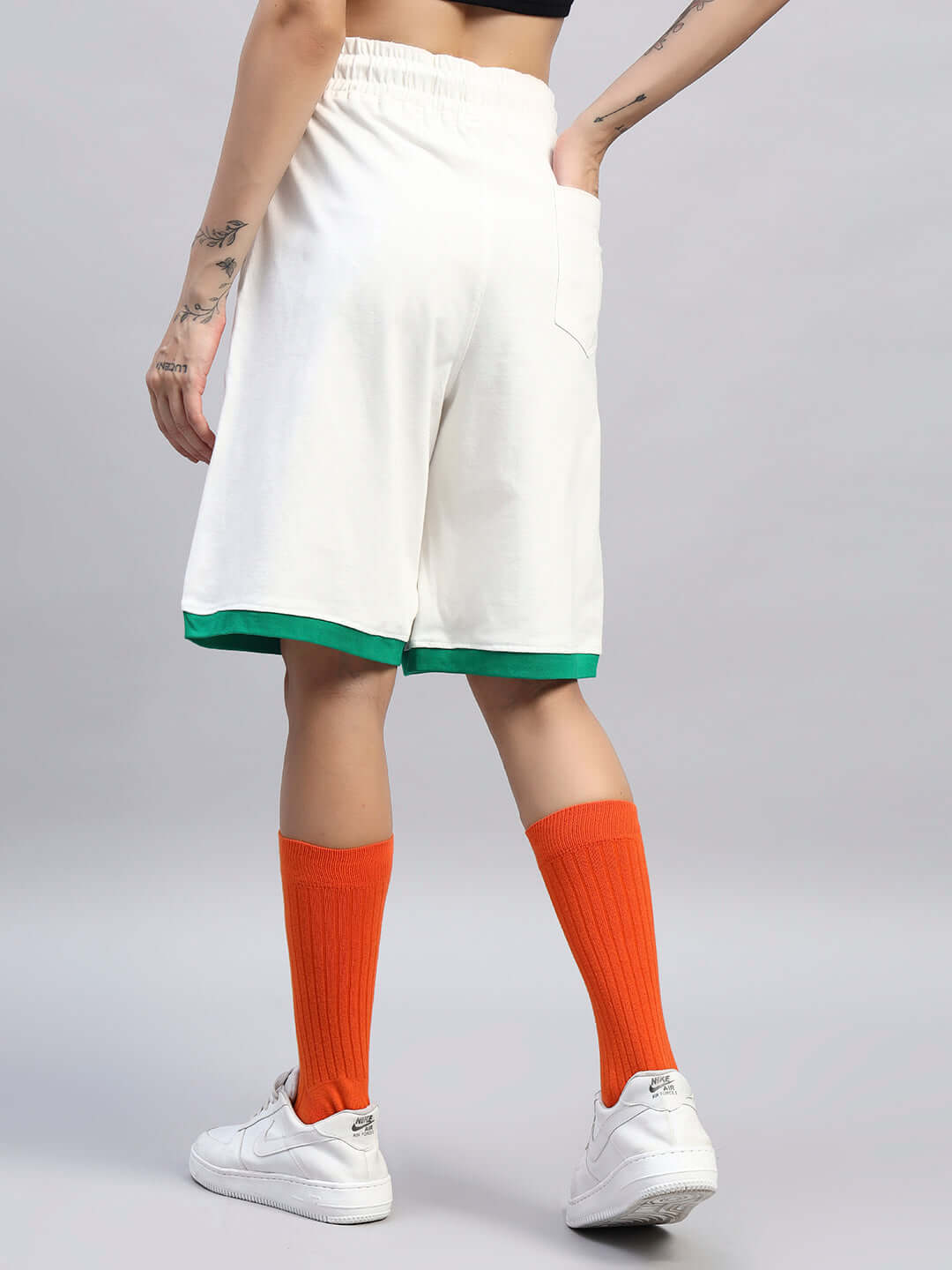 Back view of WOMEN'S DRIBBLE SUMMER SHORTS OFF-WHITE worn with orange socks and white sneakers
