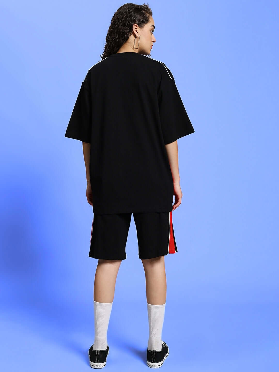 Back view of model wearing WOMEN'S DRIFT SUMMER CO-ORD SET BLACK with blue background