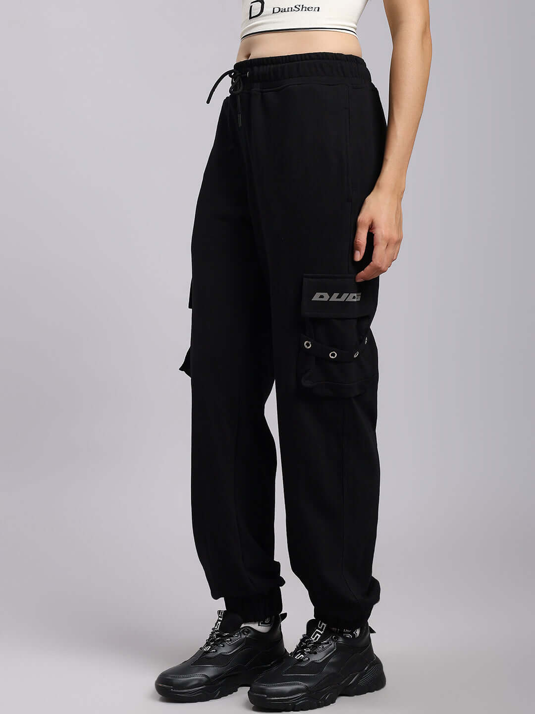 Woman wearing black DUDS Commando Joggers, showcasing adjustable fit and comfort. Perfect for custom tailoring and style enthusiasts.