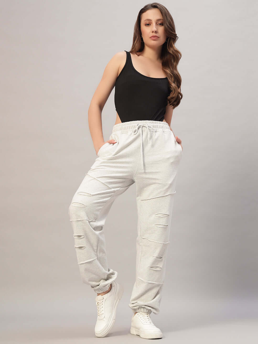 Woman wearing Women's DUDS Graze Joggers in melange grey with a black top, posing against a neutral background.