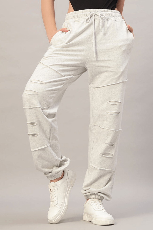 Woman wearing Women's Duds Graze Joggers in Melange Grey with drawstring waist and tapered fit, paired with white sneakers.