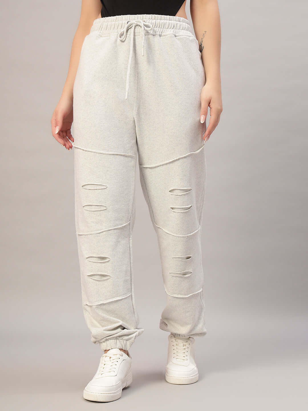 Women's DUDS Graze Joggers in melange grey with distressed detailing, worn with white sneakers.