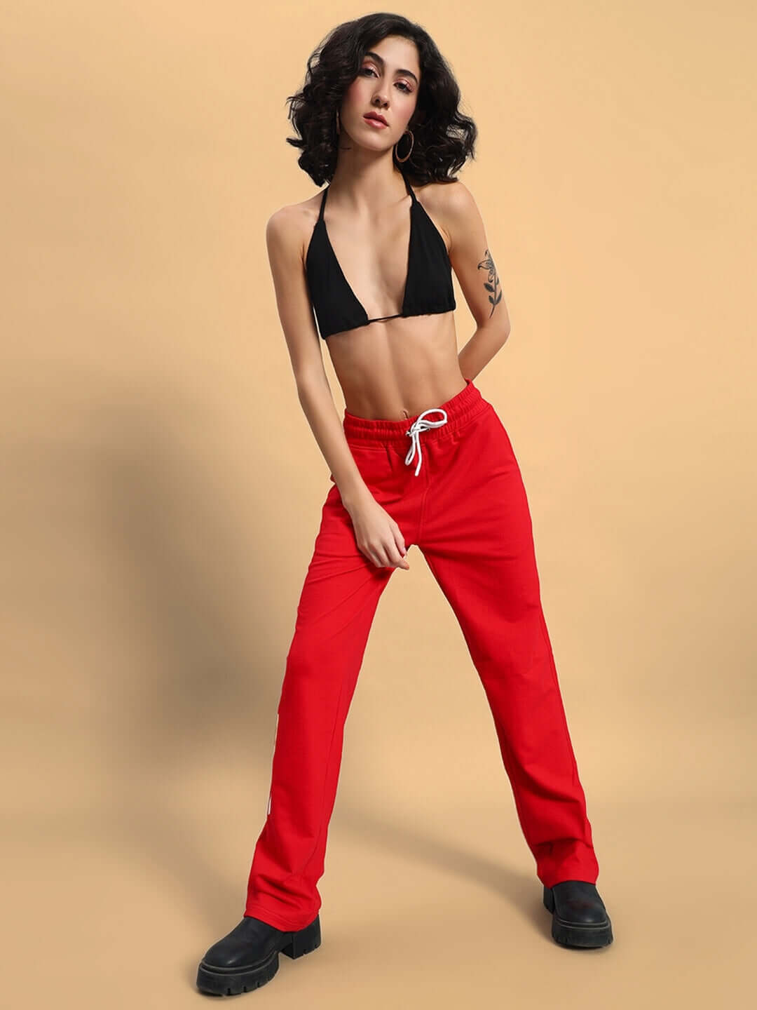 Model wearing Women's DUDS Limited Edition Red Jogger with black top, showcasing made-to-order style and customizable fit options.