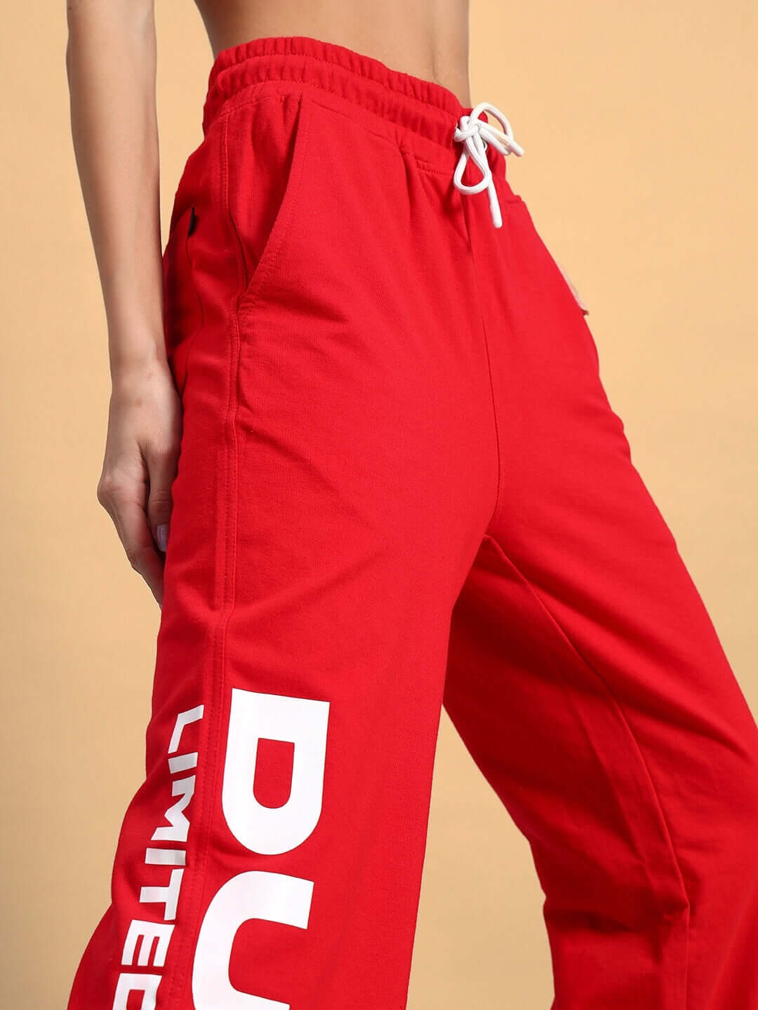 Red women's jogger pants with 'LIMITED' text, featuring an adjustable drawstring and side pockets, suitable for custom sizing.