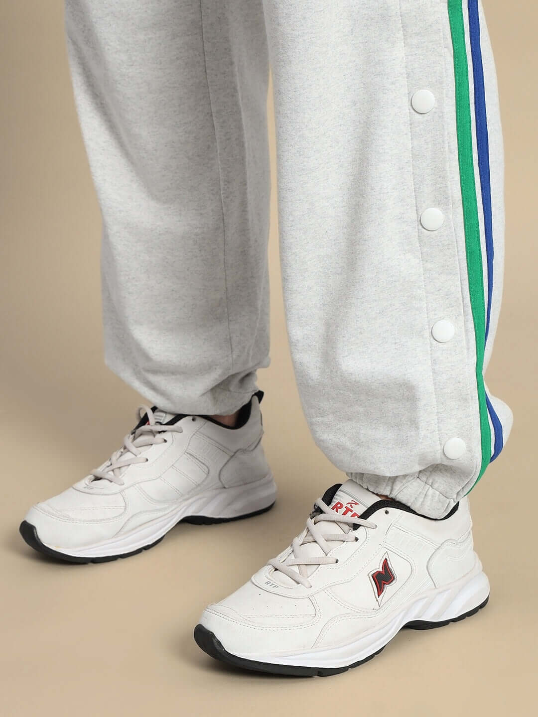 Women's DUDS Prism colorful stripe joggers in melange grey with side buttons, paired with white sneakers.
