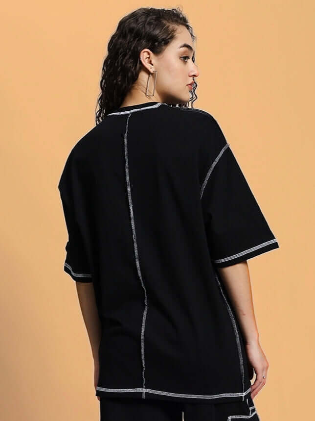 Model wearing Women's Dynamic Over-Sized Classic Black T-Shirt, featuring premium cotton French terry fabric with contrasting seams, back view.