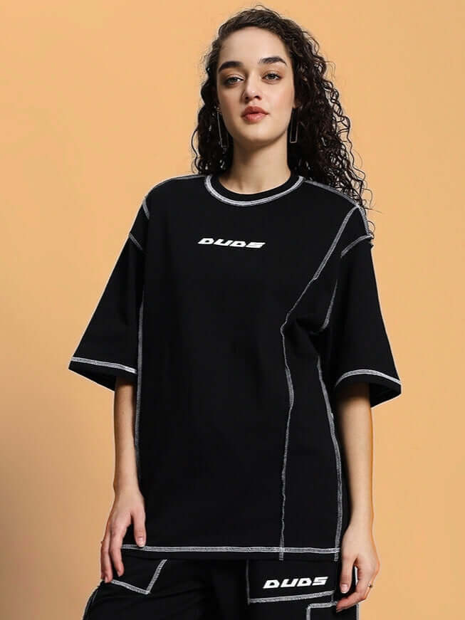 Woman wearing black oversized classic t-shirt with contrast stitching, made from premium heavy gauge fabric, showcasing stylish design.