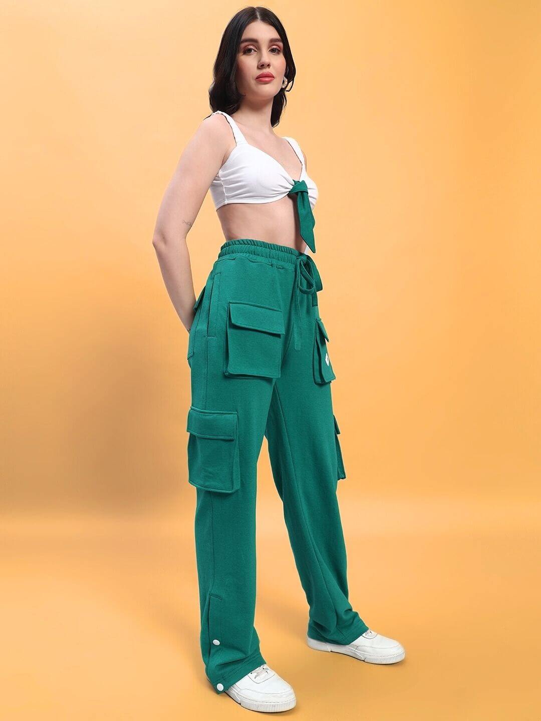 Model wearing WOMEN'S EASTON CO-ORD SET WHITE-GREEN with white top and green pants, showcasing casual style on a yellow background.