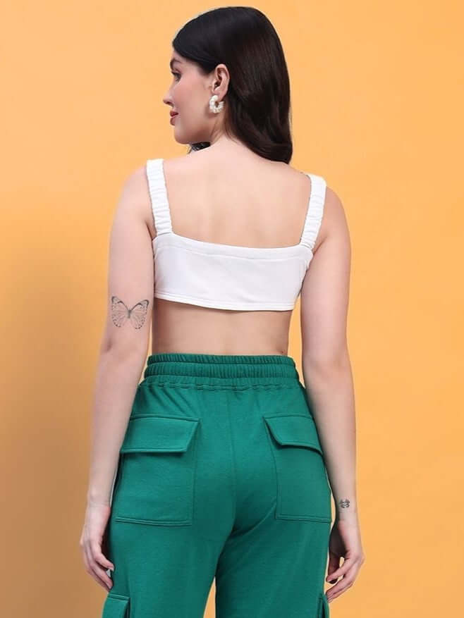 Back view of a woman wearing a white Easton crop-top and green pants, showcasing premium cotton fabric and stylish design.