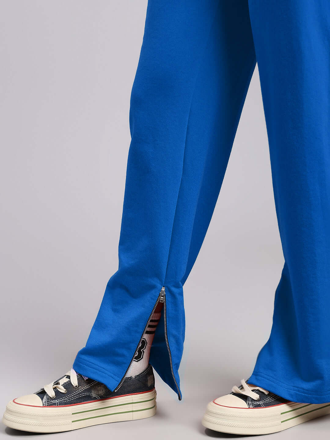 Close-up of WOMENS ELEGANT RELAXED-FIT JOGGERS BLUE with sneakers, showcasing the comfortable fit and stylish side zipper detail.