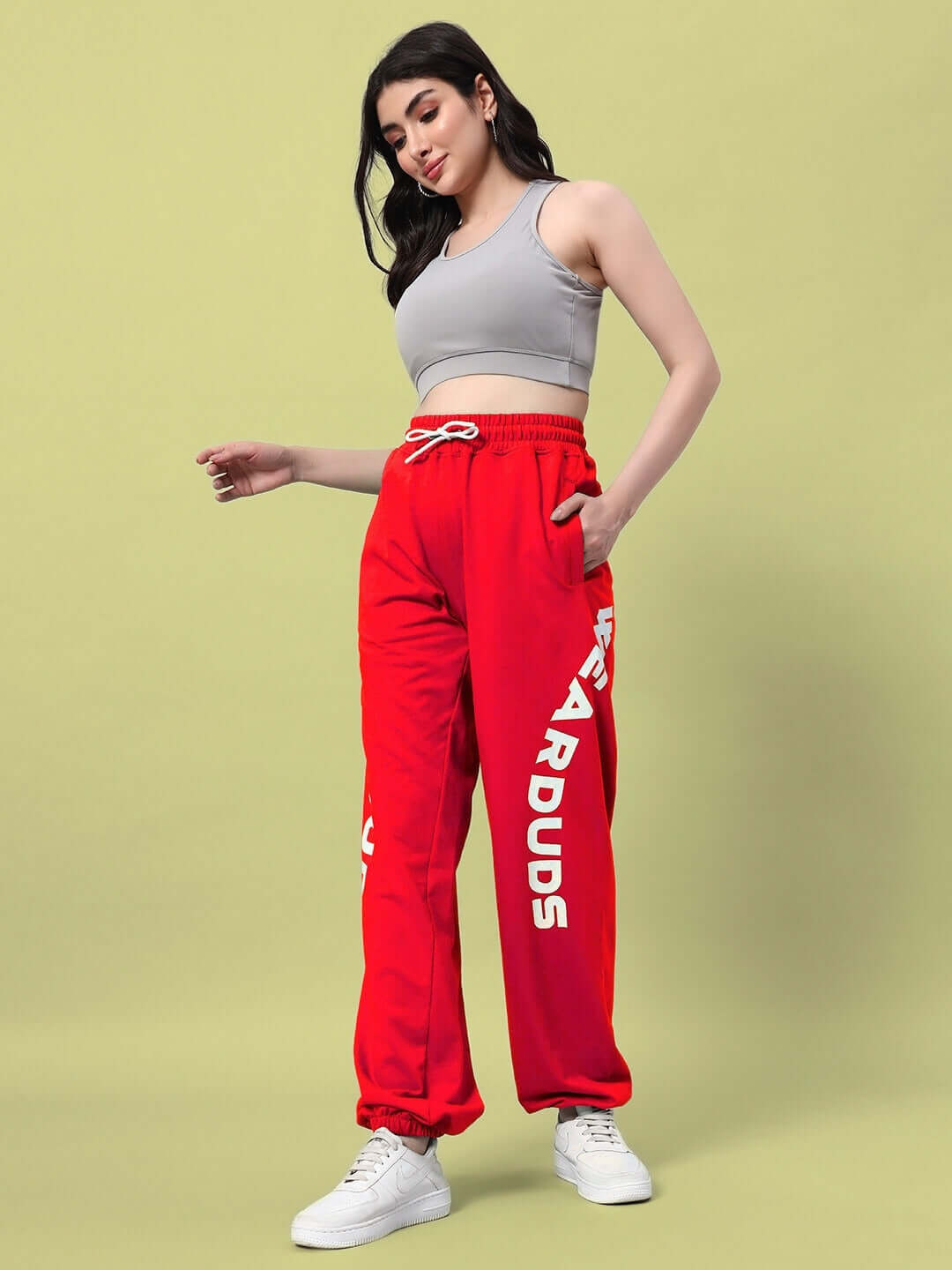 Woman wearing red Ellen Relaxed Fit Jogger with a grey crop top, styled with white sneakers, designed by DUDS.