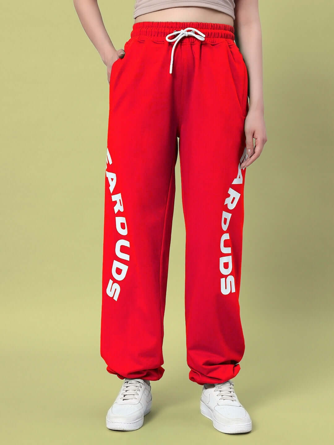 Woman wearing red Ellen relaxed fit jogger by DUDS, featuring custom fit options and white logo print on sides.