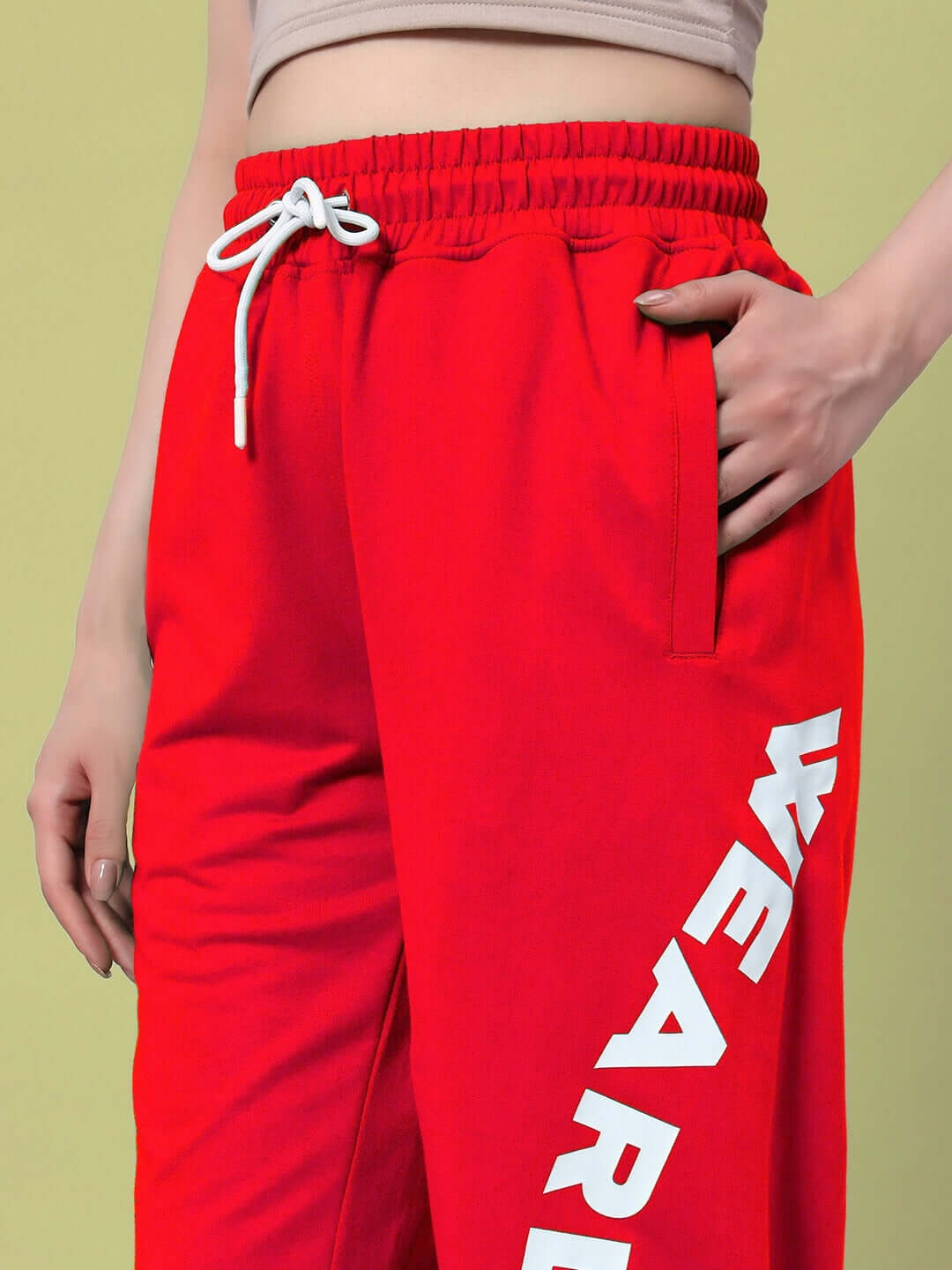 Close-up of WOMEN'S ELLEN RELAXED FIT JOGGER RED with white drawstrings and bold lettering down the leg, showcasing vibrant style and comfort.