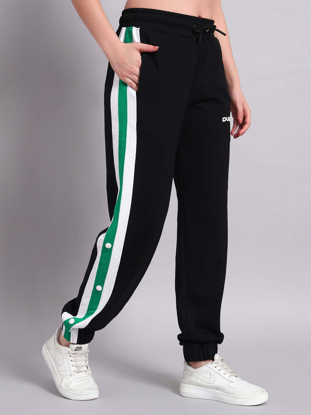 Women's Emirati Stripes Joggers in black and green with custom fit option, crafted by DUDS tailors, shown on model with sneakers.