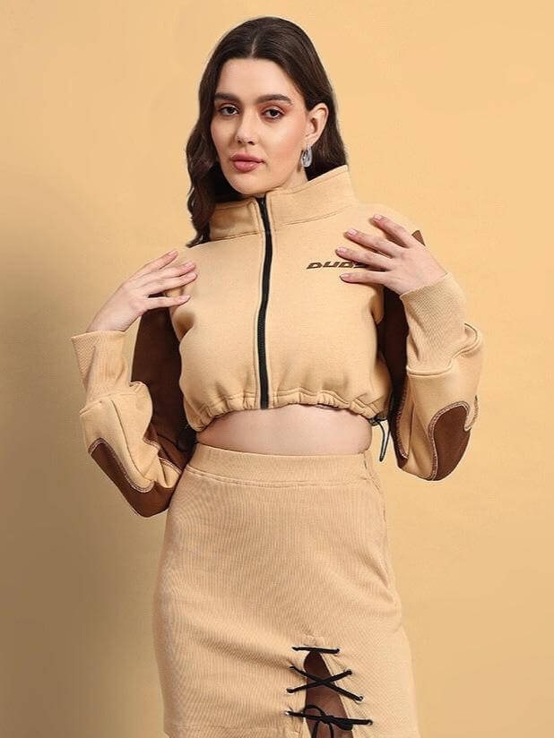 Woman wearing a beige Emma designer skirt paired with a cropped jacket, showcasing fashion style and elegance.