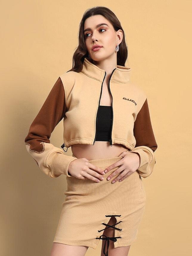 Woman wearing a stylish brown-beige cropped shacket and matching skirt ensemble against a beige backdrop.