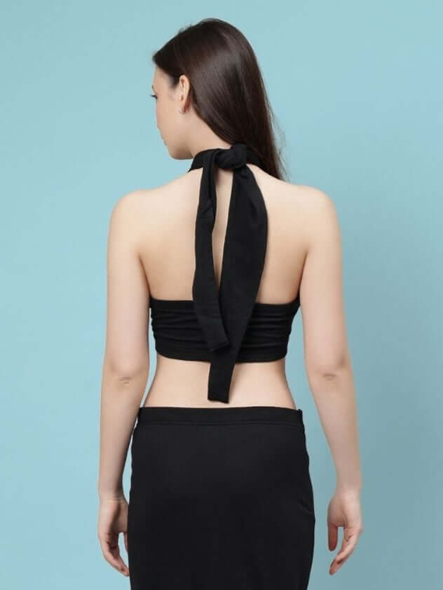 Back view of a woman wearing a black Erza Warp crop-top with ties, made from premium heavy gauge cotton, styled against a blue background.