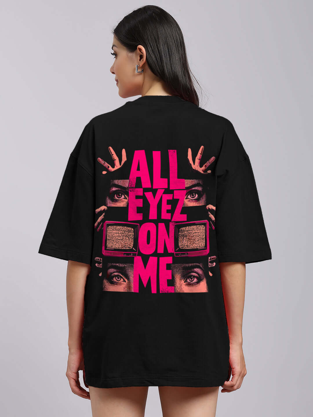 Back view of women's oversized black printed T-shirt with graphic design and text 'ALL EYEZ ON ME' in pink.
