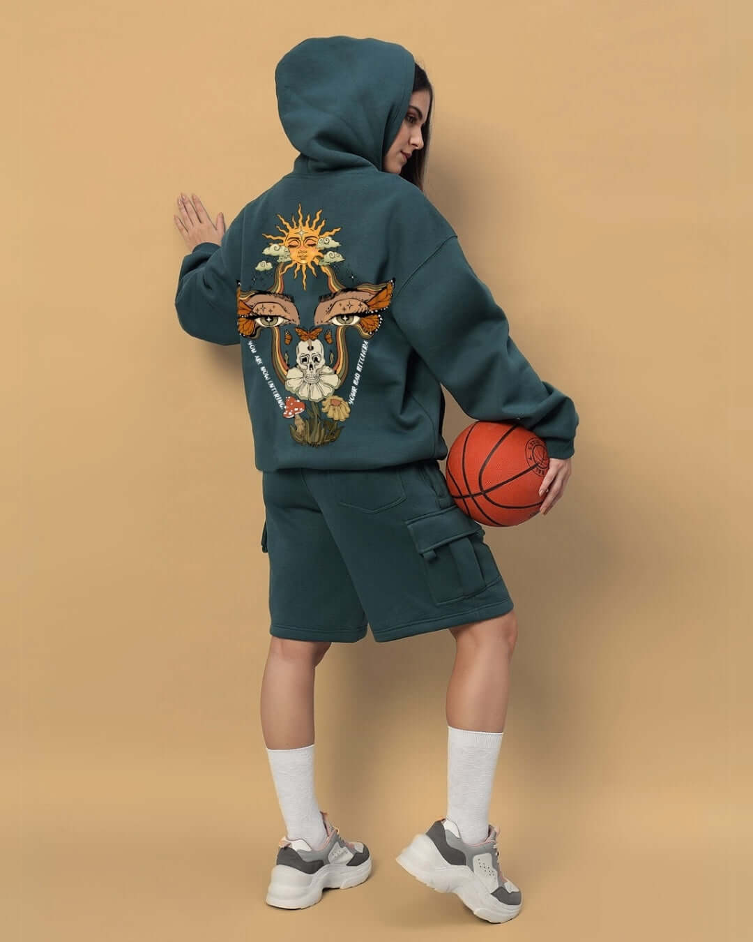 Woman wearing WOMEN'S EYES ON RISE FLEECE CO-ORD TEAL GREEN with unique back design holding basketball