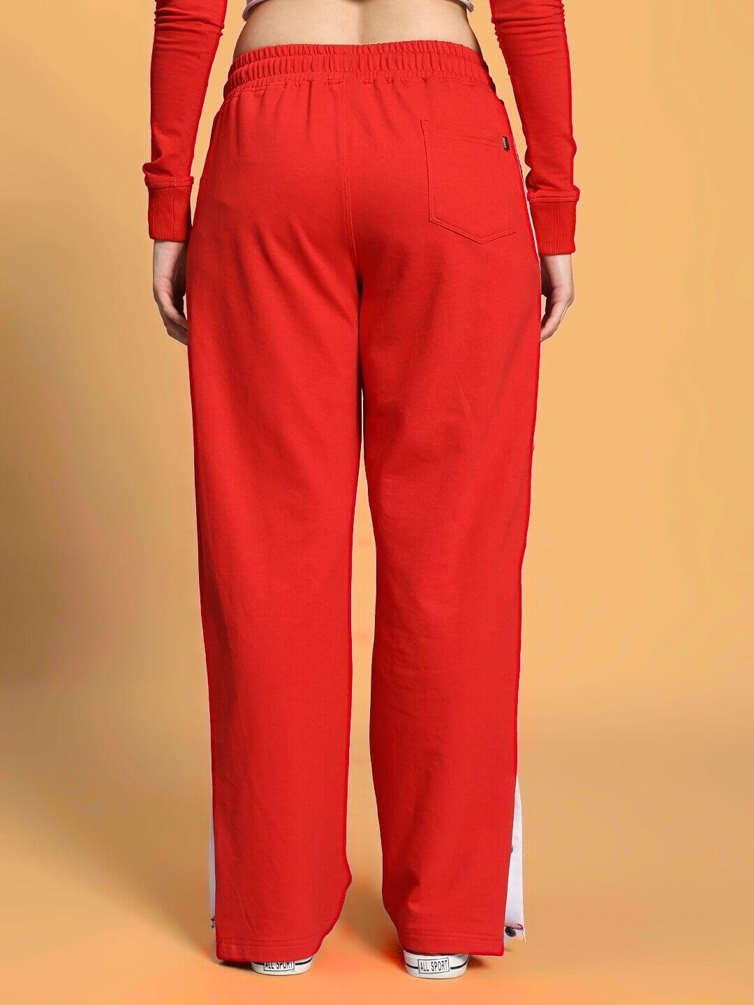 Back view of model wearing WOMEN'S EZEL CO-ORD SET RED-WHITE with red pants and long sleeves, showcasing sporty and confident style.