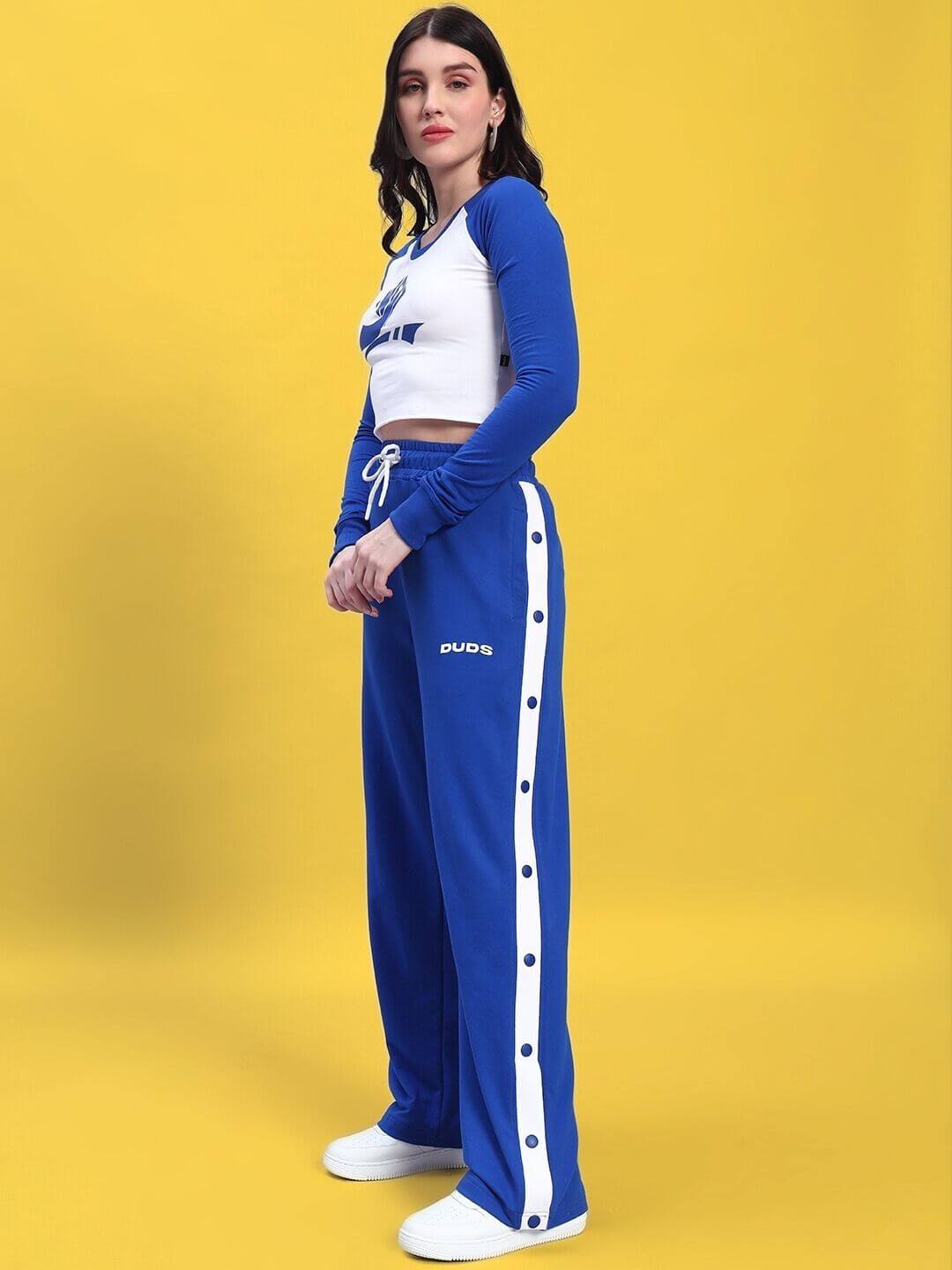 WOMEN'S EZEL CO-ORD SET ROYAL BLUE-WHITE featuring a stylish woman in a royal blue top and white bottoms against a yellow background.