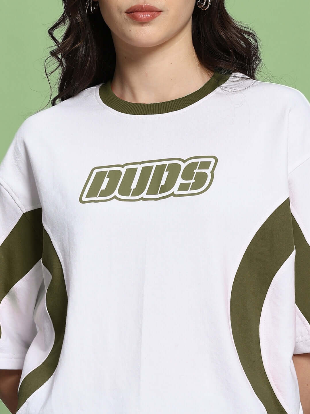 White olive green oversized women's t-shirt, featuring bold text design, made from premium cotton blend, on model with green background.