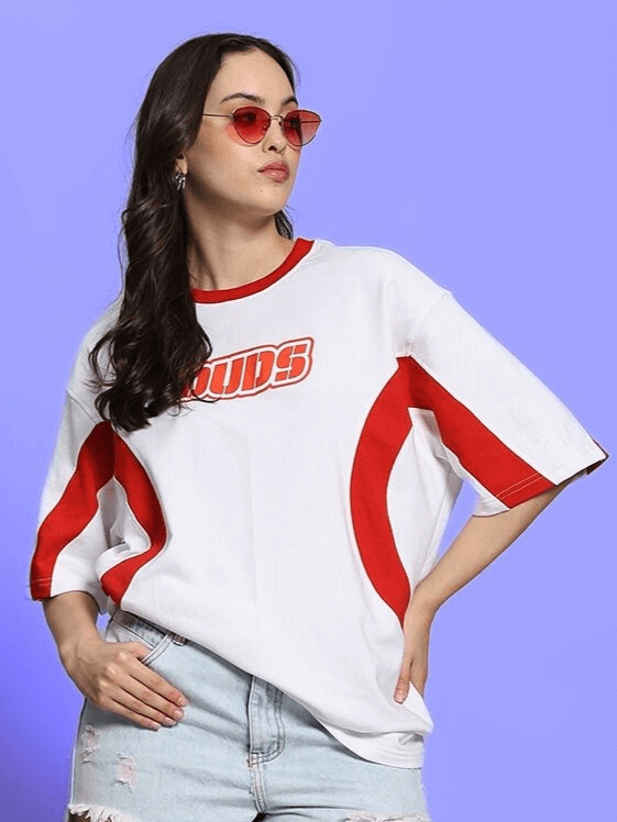 Model wearing women's Ezel oversized white-red T-shirt, featuring premium heavy gauge fabric blend, styled with sunglasses and denim shorts.
