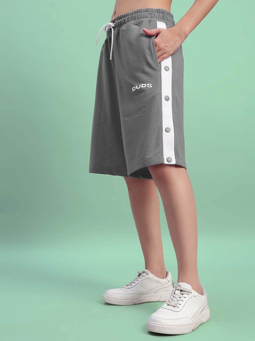 Model wearing women's grey regular fit shorts with buttoned side detail, showcasing casual style, available from DUDS with custom fit option.