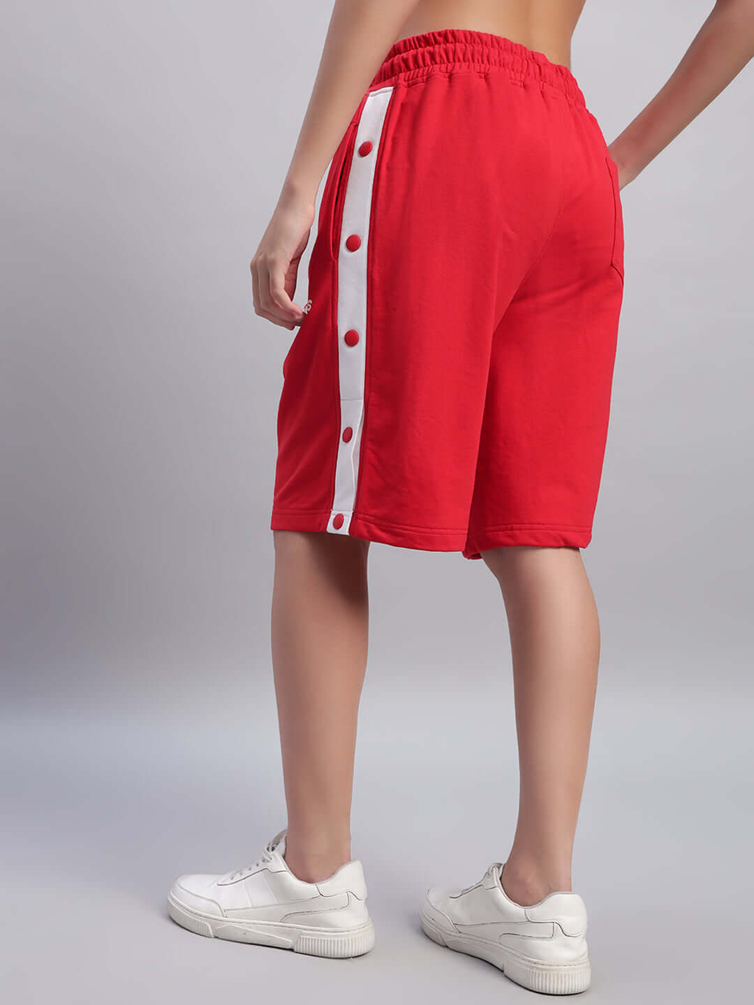 Side view of Women's Ezel Regular Fit Shorts in red, featuring white button accents, showcasing style and comfort.