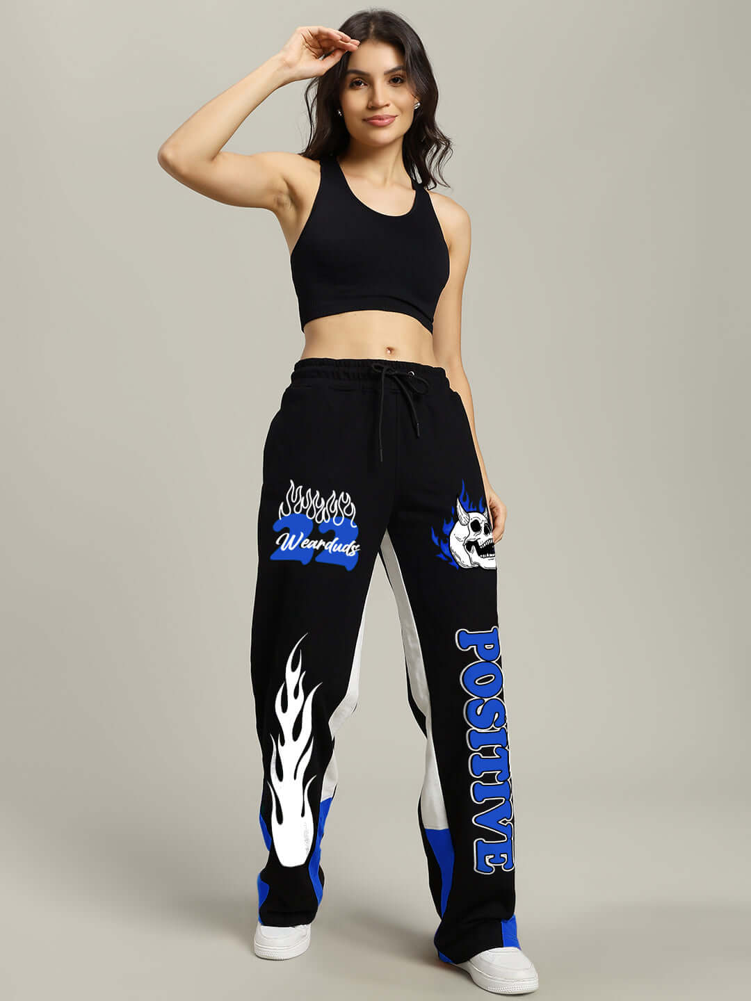 Woman wearing Women's Fearless Contrast Positive Relaxed Fit Joggers in black and blue, displaying stylish graphics and casual design.